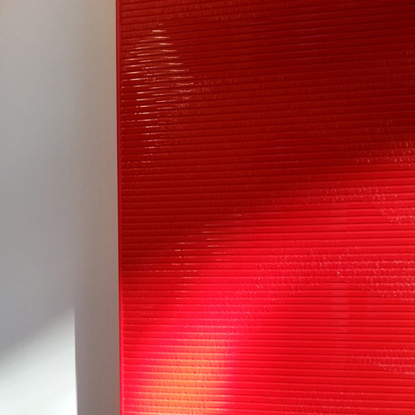 Rote Kunststeinwasserwand im Treppenhaus der Sparkasse